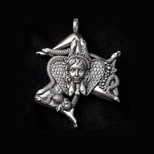 Detailed view of a handcrafted sterling silver Trinacria pendant by Indigo Jewelry. The design features a central Medusa Gorgon head with expressive facial features, surrounded by three bent running legs and interwoven stalks of wheat, symbolizing Sicilian heritage and fertility. The oxidized silver finish highlights the intricate mythological textures. This authentic Mediterranean protection amulet is shown as a high-quality statement piece for women's jewelry collections.