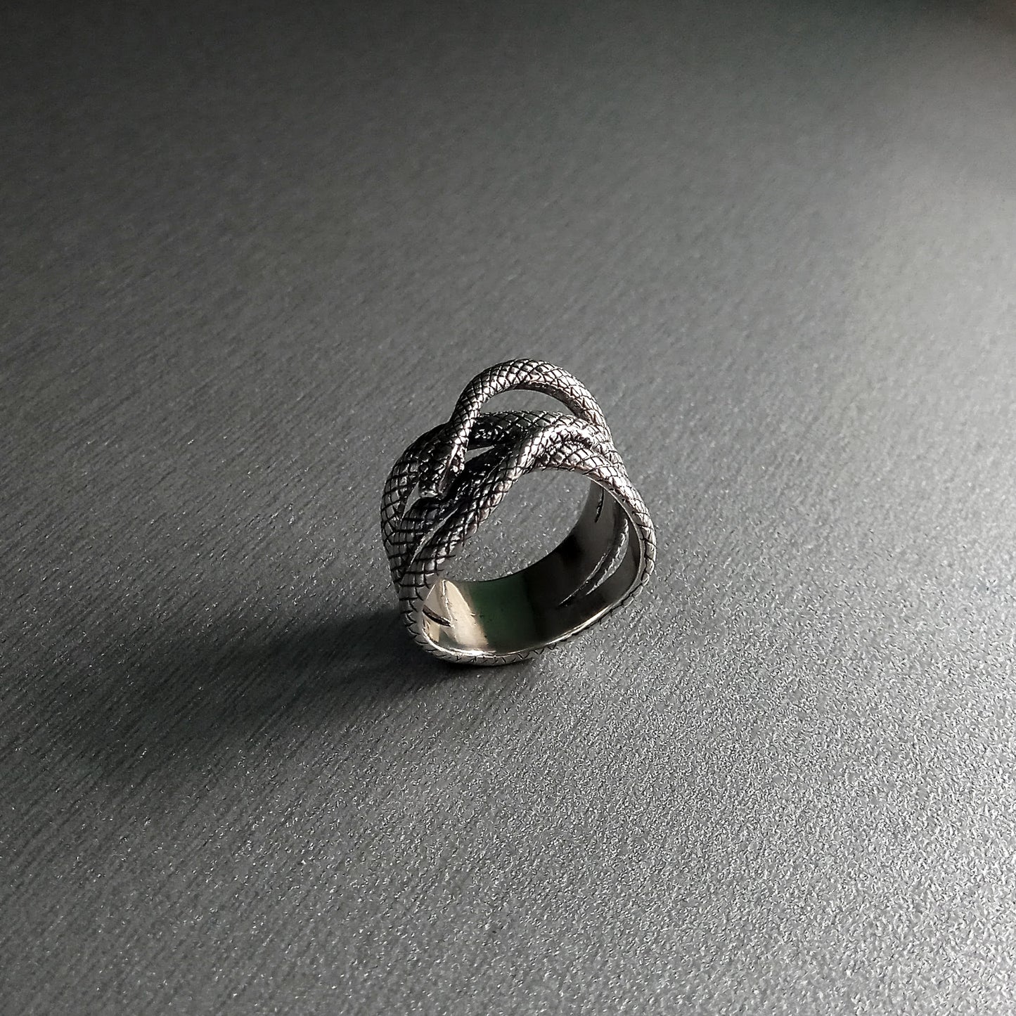 This elegant sterling silver snake ring wraps gracefully around the finger, featuring shimmering white zircon eyes that add a hypnotic, mystical touch. Inspired by the symbolism of transformation, wisdom, and feminine energy, the snake becomes a powerful totem for those who embrace intuition and inner strength. Handcrafted from 925 silver, this ring is a bold yet graceful statement piece — perfect for those who love mysterious, nature-inspired jewelry