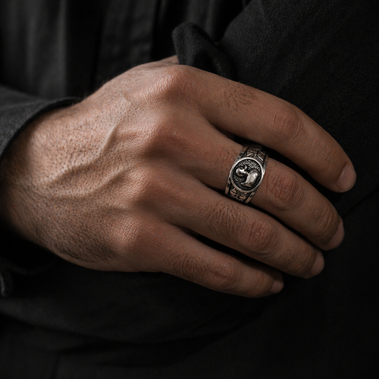 A close-up of a person's hand wearing a ring on the ring finger.