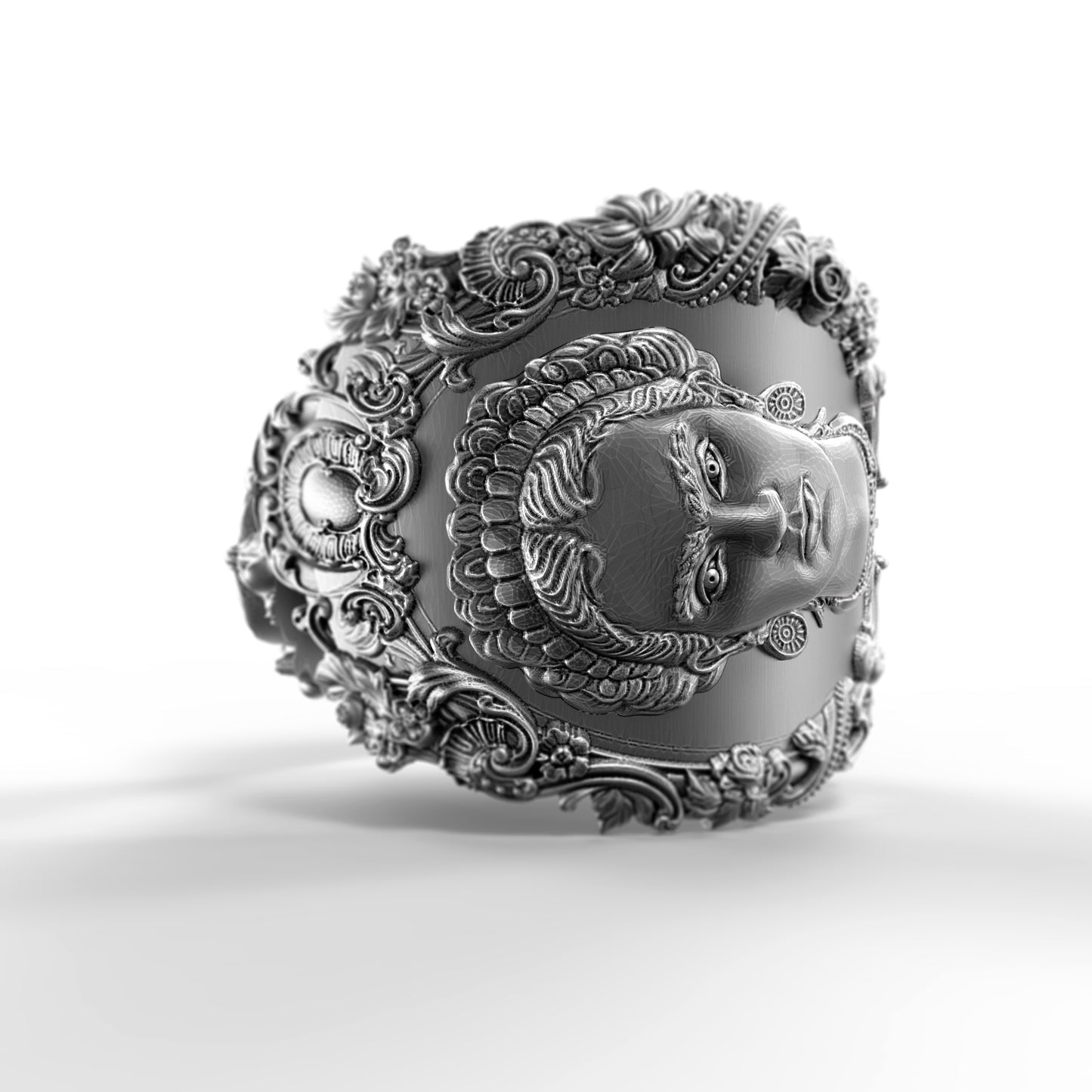 A highly detailed and ornate silver-colored metal piece, featuring an intricate design with a face or profile of a person's head.