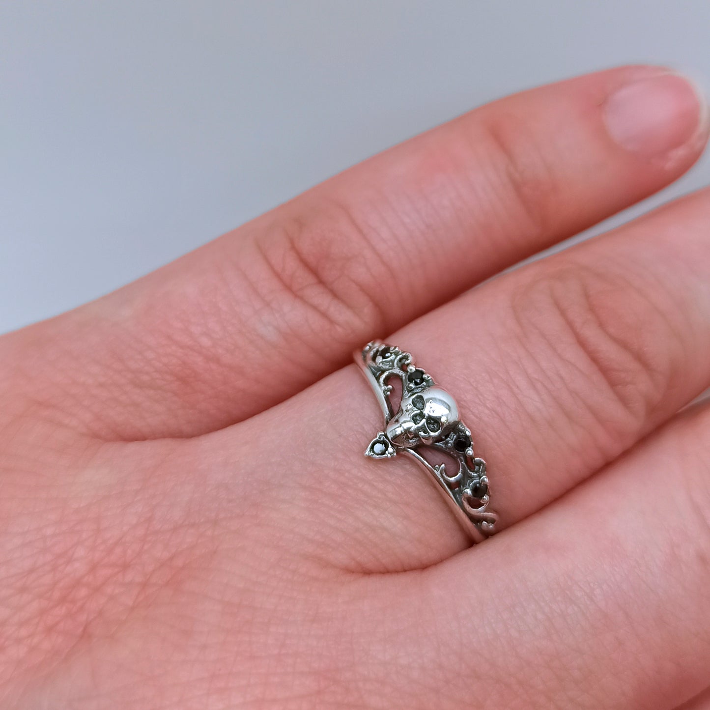 Sterling silver gothic skull ring for women with black cubic zirconia stones in a filigree crown setting. Perfect as a gothic engagement ring, witch ring, or promise ring for her. Inspired by Santa Muerte and dark romantic symbolism. A cool small silver ring and powerful piece of gothic jewelry for weddings or everyday wear. INDIGO JEWELRY