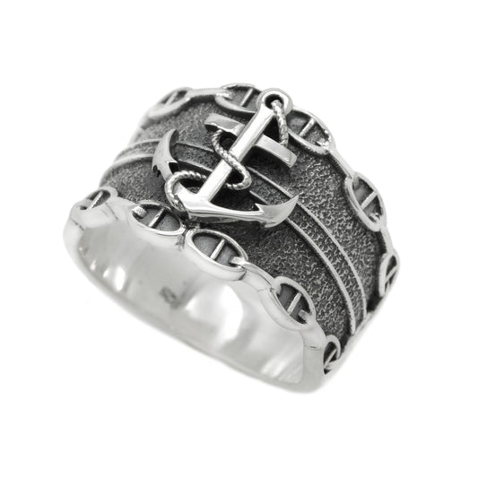 Sterling silver sailor ring for men featuring a raised anchor detail with golden or silver overlay. Nautical signet ring with blackened texture and marine chain accents. Ocean-inspired men's jewelry, perfect gift for sea lovers, navy fans, or pirate-themed collections. Handmade silver ring with sailor and maritime symbolism. INDIGO JEWELRY