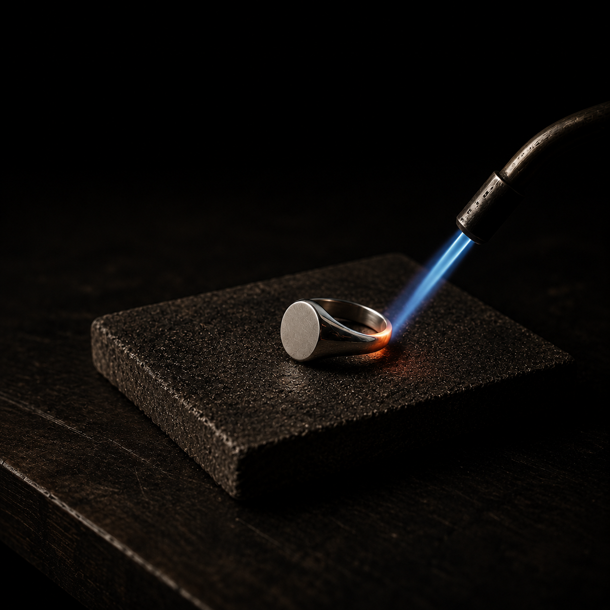 Jewelry Repair Services collection by Indigo Jewelry featuring a professional jewelry soldering process with a silver ring being repaired by torch flame. Expert repair services for rings, chains and fine jewelry restoration.