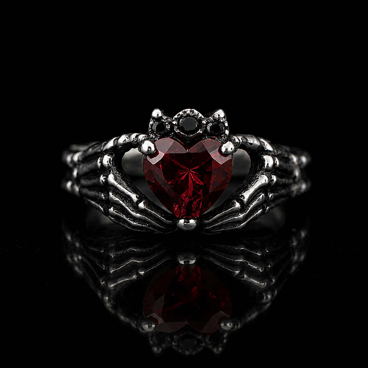 Love Till Death collection by Indigo Jewelry featuring a handcrafted sterling silver ring with a deep red heart gemstone and symbolic skeletal design. Romantic jewelry inspired by devotion, eternal connection and timeless dark elegance.