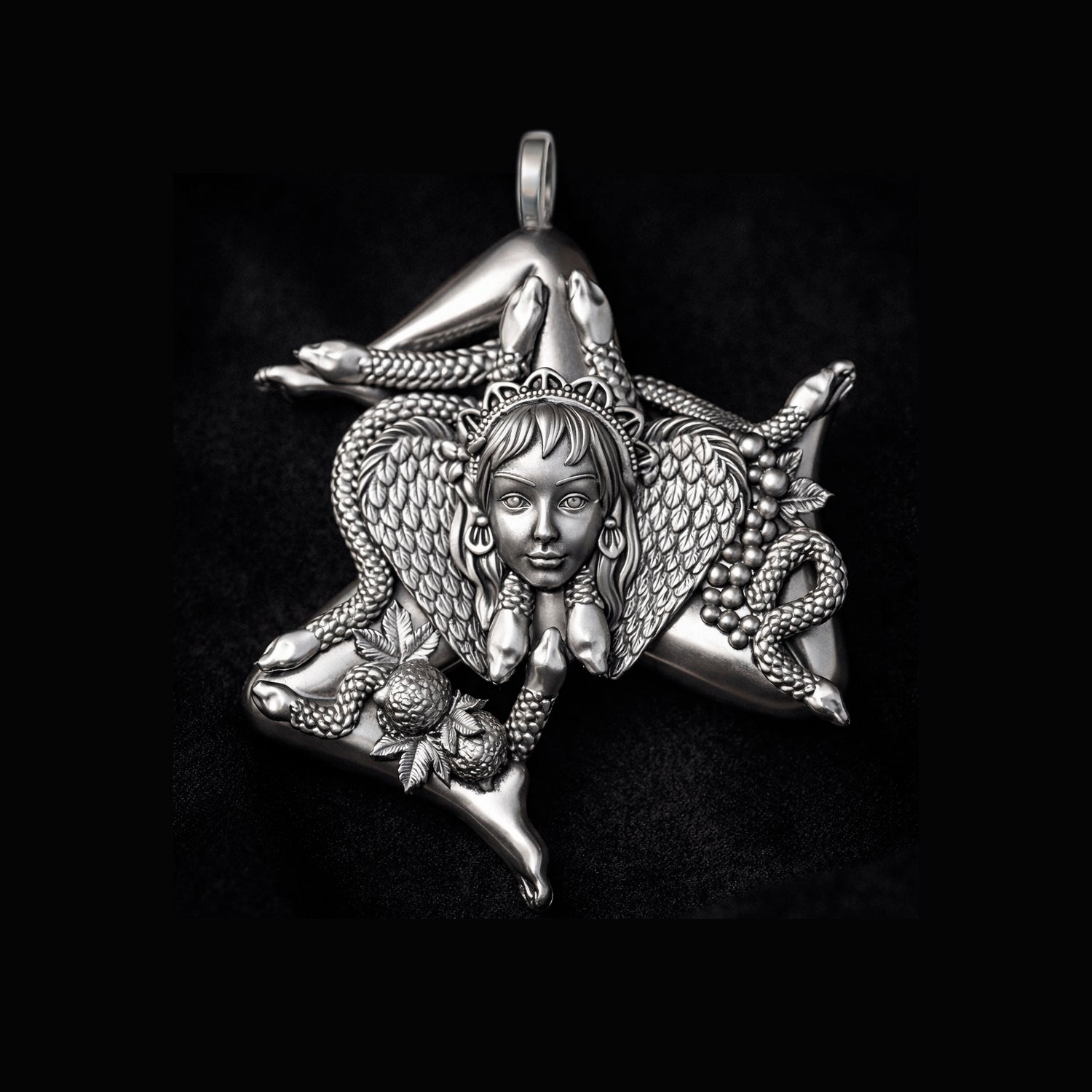 Detailed view of a handcrafted sterling silver Trinacria pendant by Indigo Jewelry. The design features a central Medusa Gorgon head with expressive facial features, surrounded by three bent running legs and interwoven stalks of wheat, symbolizing Sicilian heritage and fertility. The oxidized silver finish highlights the intricate mythological textures. This authentic Mediterranean protection amulet is shown as a high-quality statement piece for women's jewelry collections.