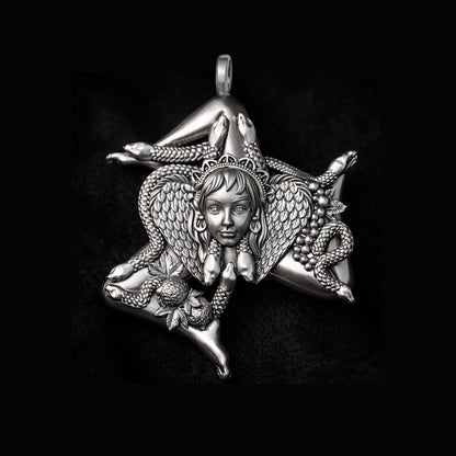 Detailed view of a handcrafted sterling silver Trinacria pendant by Indigo Jewelry. The design features a central Medusa Gorgon head with expressive facial features, surrounded by three bent running legs and interwoven stalks of wheat, symbolizing Sicilian heritage and fertility. The oxidized silver finish highlights the intricate mythological textures. This authentic Mediterranean protection amulet is shown as a high-quality statement piece for women's jewelry collections.