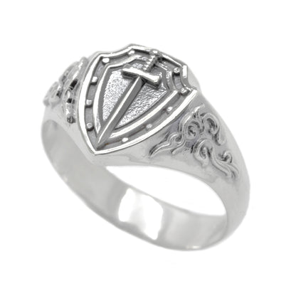 A silver ring with a shield-shaped design featuring a sword and intricate patterns.