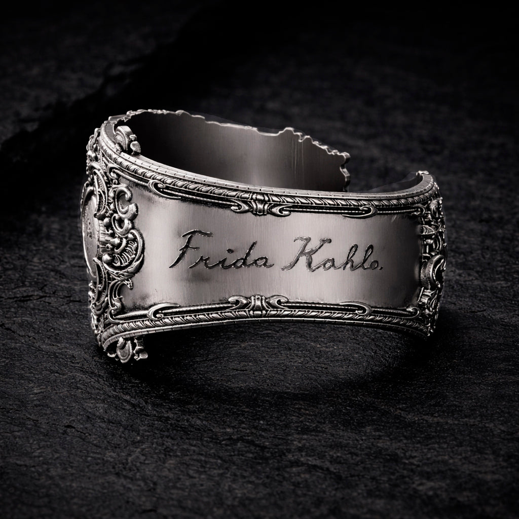 Open oxidized silver thumb ring featuring a detailed portrait of Frida Kahlo. Artistic spoon ring inspired by vintage silverware jewelry, designed as an open ring that wraps tightly around the thumb. Statement thumb ring with sculptural relief and darkened recessed details, handcrafted art jewelry. Frida Kahlo open ring made of blackened silver, bold spoon ring for the thumb, unique wearable art.
