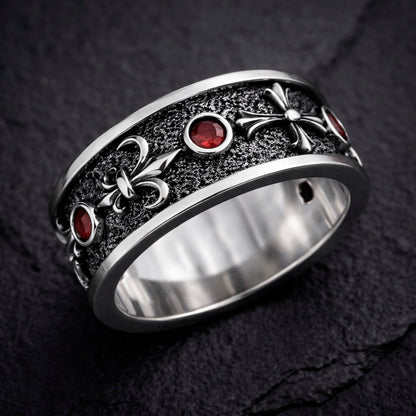 Sterling silver Fleur De Lis ring with deep red garnet stones, featuring an oxidized textured finish and polished heraldic symbols. Medieval gothic band ring inspired by knightly and royal motifs. Solid 925 silver statement ring suitable as a wedding band or symbolic jewelry piece. Elegant, bold, and historically inspired design for men or women, perfect for gothic style, medieval fashion, and unique meaningful gifts.