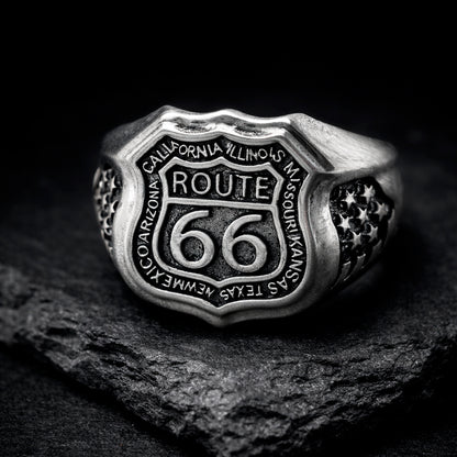 Route 66 sterling silver ring by Indigo Jewelry, men’s biker statement ring crafted from solid 925 silver with oxidized finish. Detailed Route 66 shield engraving with surrounding state names, bold vintage motorcycle jewelry design. Masculine rock style ring inspired by American highway culture, handcrafted silver band for riders, travelers, and lovers of road symbolism.