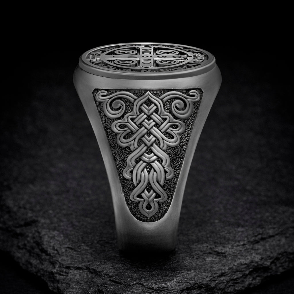 A silver ring with an intricate, decorative design on the surface.