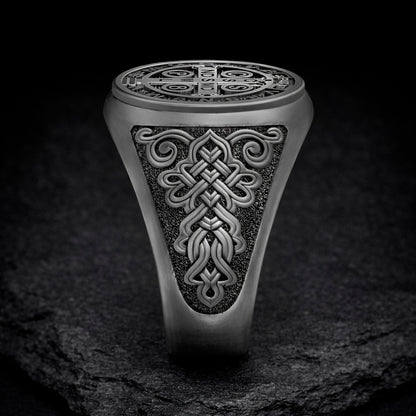 A silver ring with an intricate, decorative design on the surface.