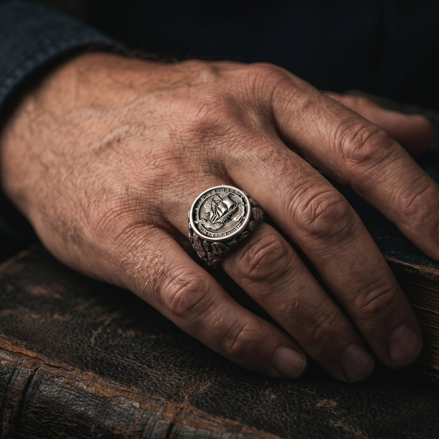Antarctica explorer signet ring in solid sterling silver 925 featuring a detailed sailing ship over a map of Antarctica, surrounded by directional markings. The ring has a deep oxidized finish with strong contrast, highlighting fine handcrafted textures and relief details. Shot on a dark stone background to emphasize its bold, masculine design, adventure theme, and expedition spirit. Unique nautical jewelry piece inspired by travel, ocean journeys, and exploration beyond the known world.