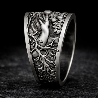 Oxidized sterling silver statement ring by Indigo Jewelry from the Human Paradox Collection. Artistic symbolic design featuring two hands reaching for the forbidden fruit, inspired by Lost Paradise and The Choice concept. Handcrafted silver ring with detailed relief, darkened blackened finish, conceptual jewelry, philosophical ring, art jewelry piece, unique designer silver ring, expressive narrative jewelry, bold textured band, meaningful wearable art.