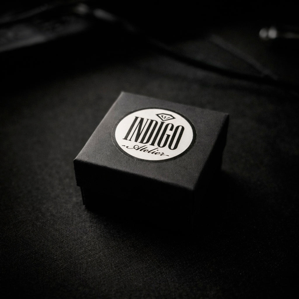A black box with a white circular label that says "INDIGO Style" on it, placed on a dark surface.