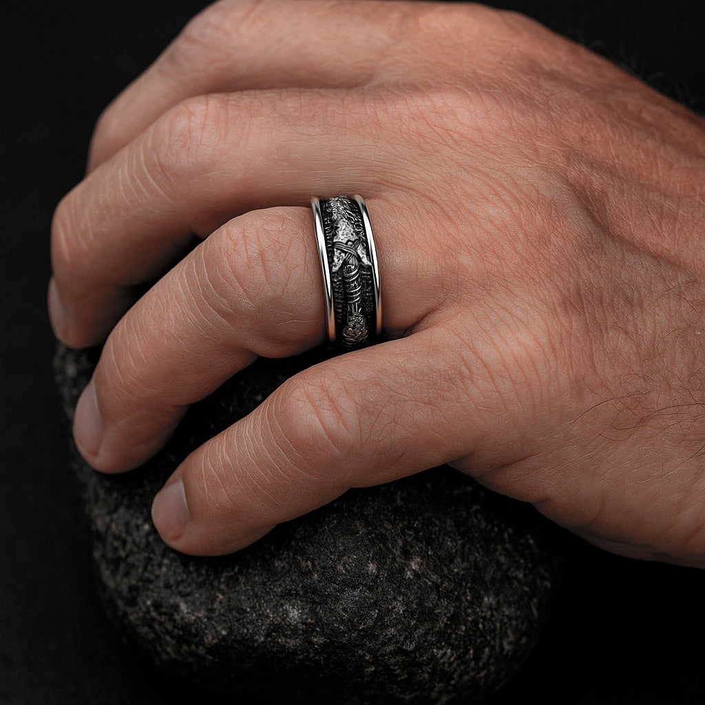 A close-up image of a hand wearing a ring, resting on a rock.