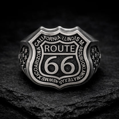 Route 66 sterling silver ring by Indigo Jewelry, men’s biker statement ring crafted from solid 925 silver with oxidized finish. Detailed Route 66 shield engraving with surrounding state names, bold vintage motorcycle jewelry design. Masculine rock style ring inspired by American highway culture, handcrafted silver band for riders, travelers, and lovers of road symbolism.