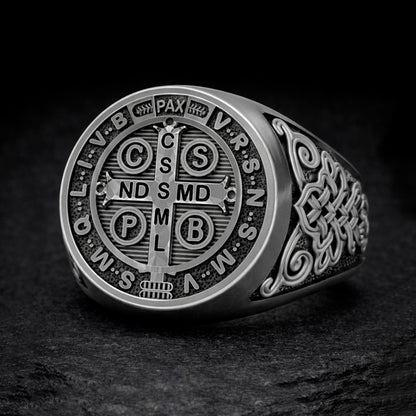 A silver ring with a circular design featuring the letters of the Catholic Church's sacred name, which is the St. Mary of the Flower of the Immaculate Conception.