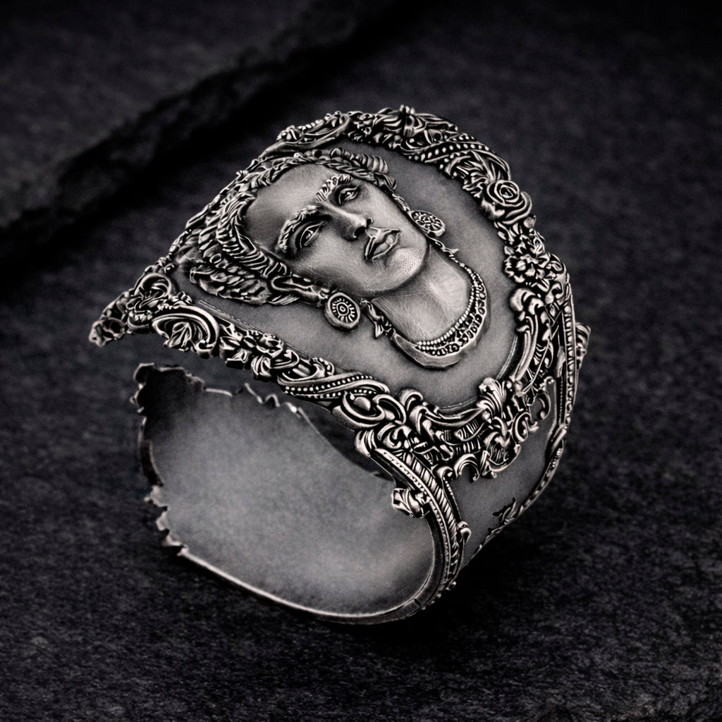 Open oxidized silver thumb ring featuring a detailed portrait of Frida Kahlo. Artistic spoon ring inspired by vintage silverware jewelry, designed as an open ring that wraps tightly around the thumb. Statement thumb ring with sculptural relief and darkened recessed details, handcrafted art jewelry. Frida Kahlo open ring made of blackened silver, bold spoon ring for the thumb, unique wearable art.