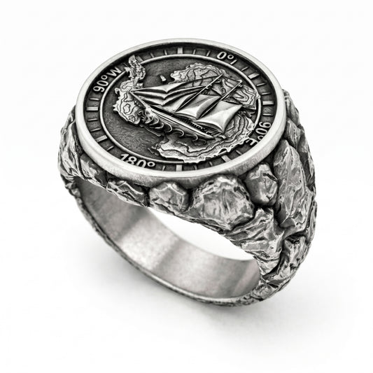 Antarctica explorer signet ring in solid sterling silver 925 featuring a detailed sailing ship over a map of Antarctica, surrounded by directional markings. The ring has a deep oxidized finish with strong contrast, highlighting fine handcrafted textures and relief details. Shot on a dark stone background to emphasize its bold, masculine design, adventure theme, and expedition spirit. Unique nautical jewelry piece inspired by travel, ocean journeys, and exploration beyond the known world.