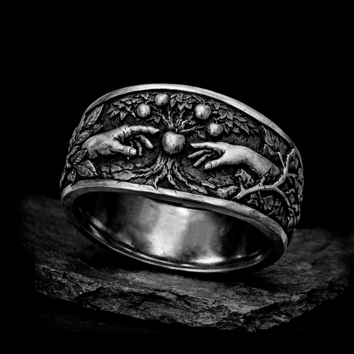 Oxidized sterling silver statement ring by Indigo Jewelry from the Human Paradox Collection. Artistic symbolic design featuring two hands reaching for the forbidden fruit, inspired by Lost Paradise and The Choice concept. Handcrafted silver ring with detailed relief, darkened blackened finish, conceptual jewelry, philosophical ring, art jewelry piece, unique designer silver ring, expressive narrative jewelry, bold textured band, meaningful wearable art.