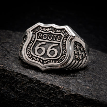 Route 66 sterling silver ring by Indigo Jewelry, men’s biker statement ring crafted from solid 925 silver with oxidized finish. Detailed Route 66 shield engraving with surrounding state names, bold vintage motorcycle jewelry design. Masculine rock style ring inspired by American highway culture, handcrafted silver band for riders, travelers, and lovers of road symbolism.