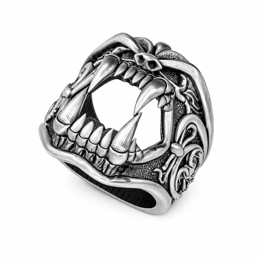 A detailed silver ring with a fierce, menacing design featuring sharp teeth and claws.