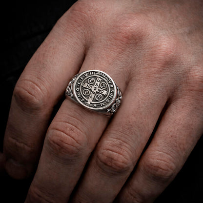A close-up of a person's hand wearing a silver ring with a circular design.