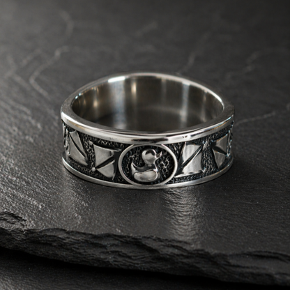 A silver ring with a decorative band featuring a small metal duck design.