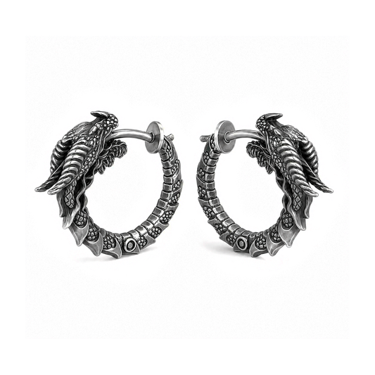 Pair of handcrafted dragon hoop earrings in oxidized sterling silver 925 by INDIGO Jewelry. Realistic gothic earrings featuring detailed dragon heads, sculpted scales, and textured segmented hoops with blackened silver finish for a dark vintage look. Displayed on a clean white background, these fantasy-inspired silver earrings combine medieval, mythical, and gothic aesthetics. Ideal statement jewelry for dragon lovers, fantasy enthusiasts, and alternative fashion.
