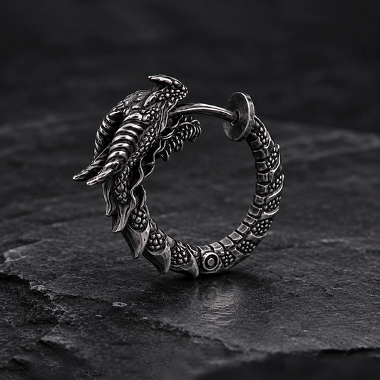 Handcrafted dragon hoop earring in oxidized sterling silver 925 by INDIGO Jewelry. Detailed gothic silver earring featuring a sculpted dragon head, textured scales, and a segmented hoop with blackened oxidized finish for a dark vintage appearance. Realistic fantasy-inspired jewelry with medieval and mythical aesthetics, designed as a bold statement piece for dragon lovers, gothic fashion, alternative style, and symbolic silver jewelry collections.
