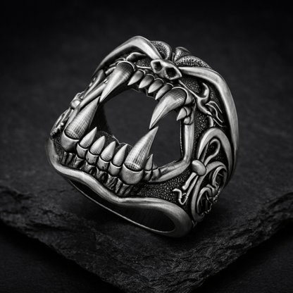 A close-up black and white image of a ring with a fierce, menacing creature design, such as a lion or tiger, with sharp teeth and claws.