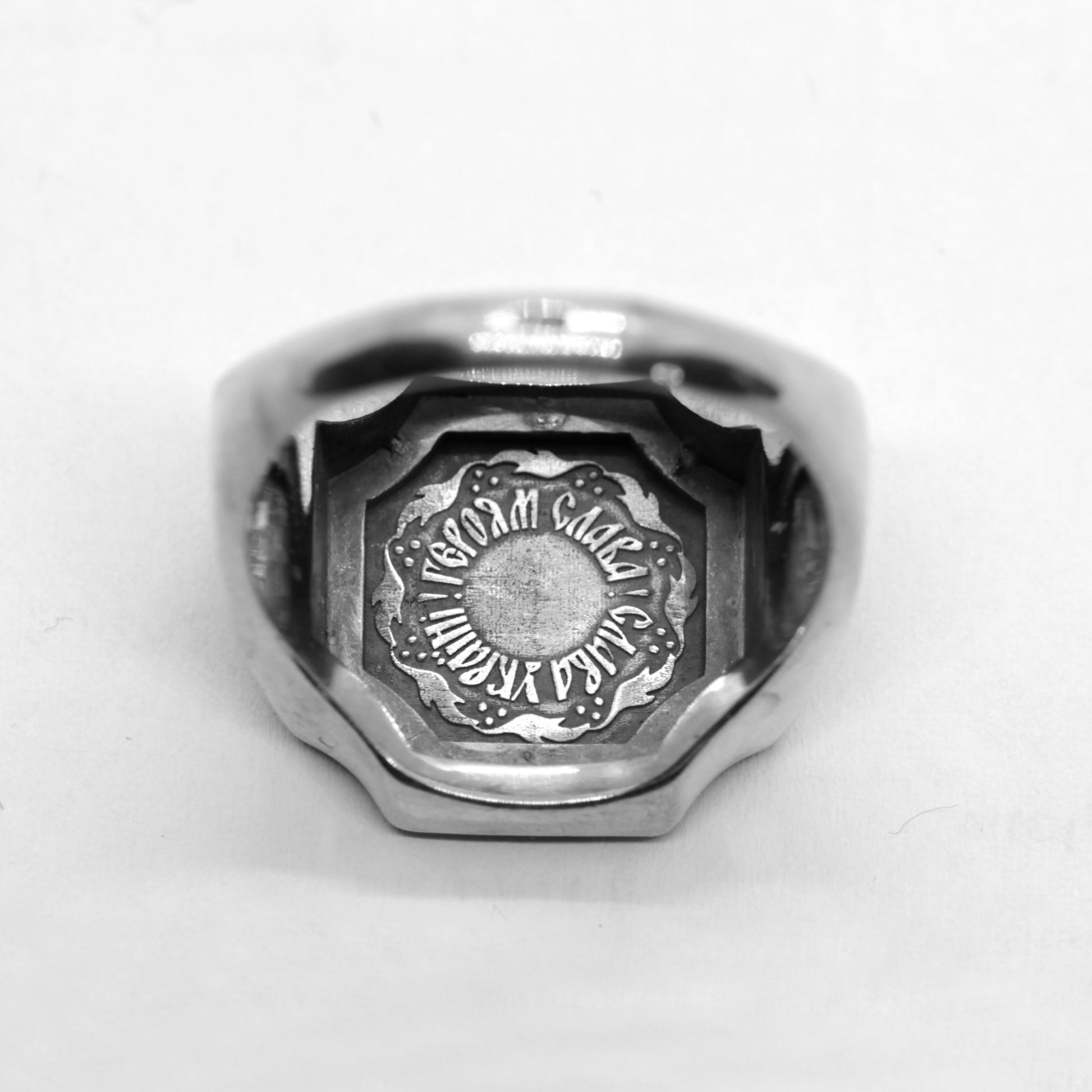 A silver ring with an embossed design on the back.