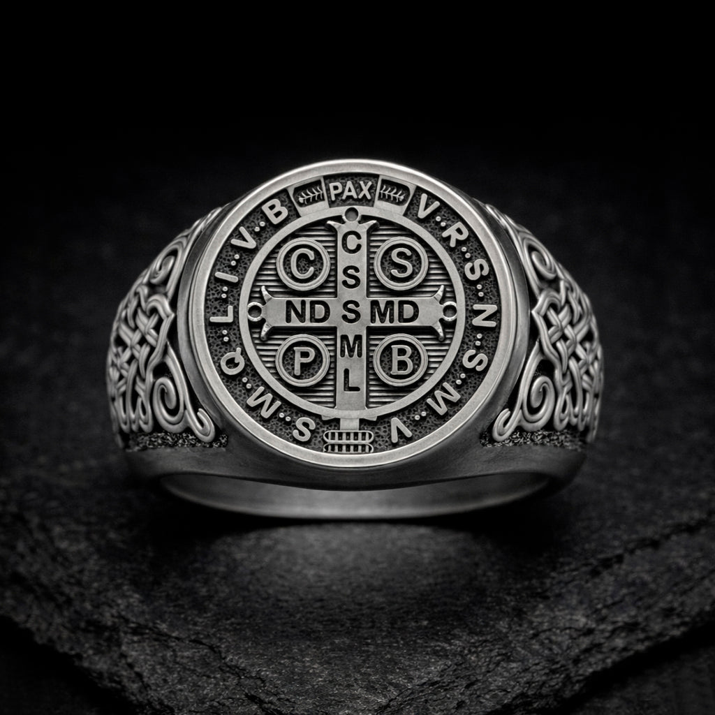 A silver ring with an intricate design featuring a cross and various religious symbols.