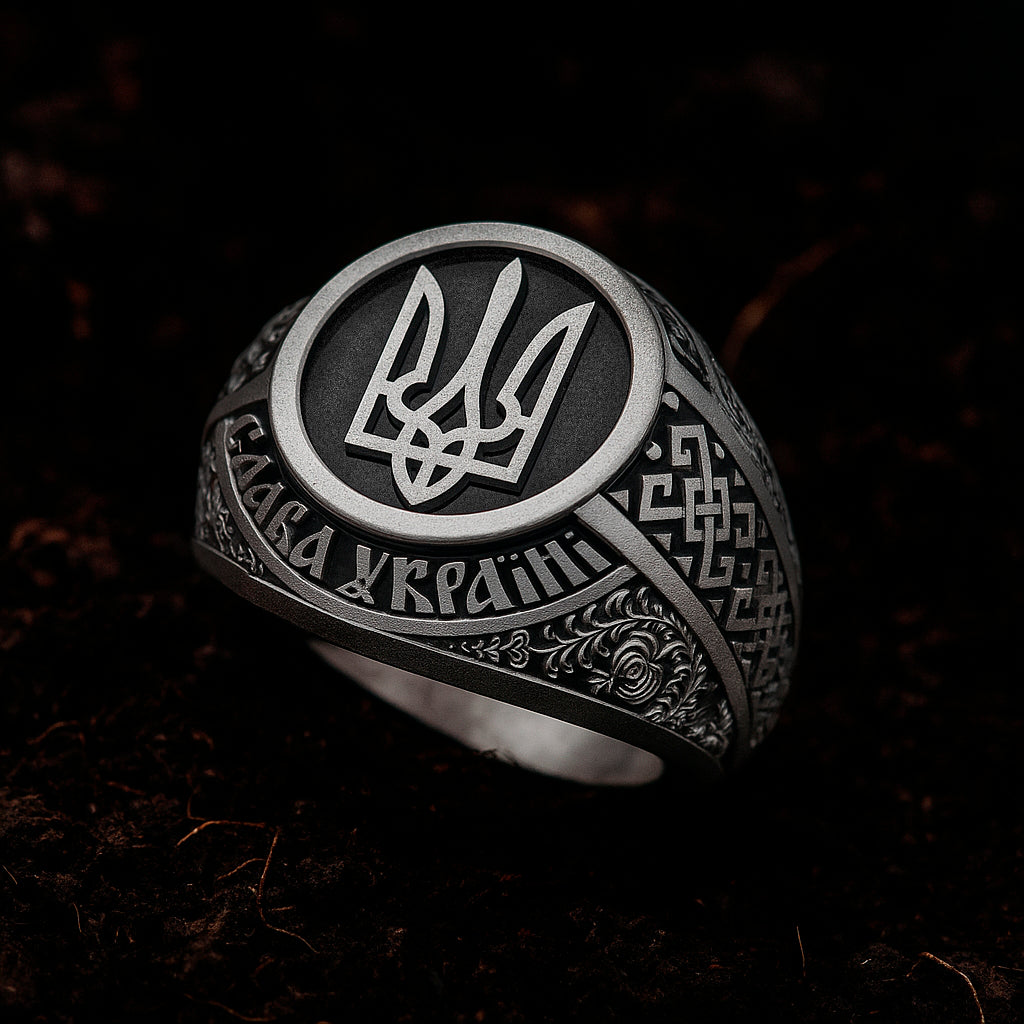 A silver ring with intricate designs and a central emblem, featuring the text "СТАНДАНЕНИЙ" on it.