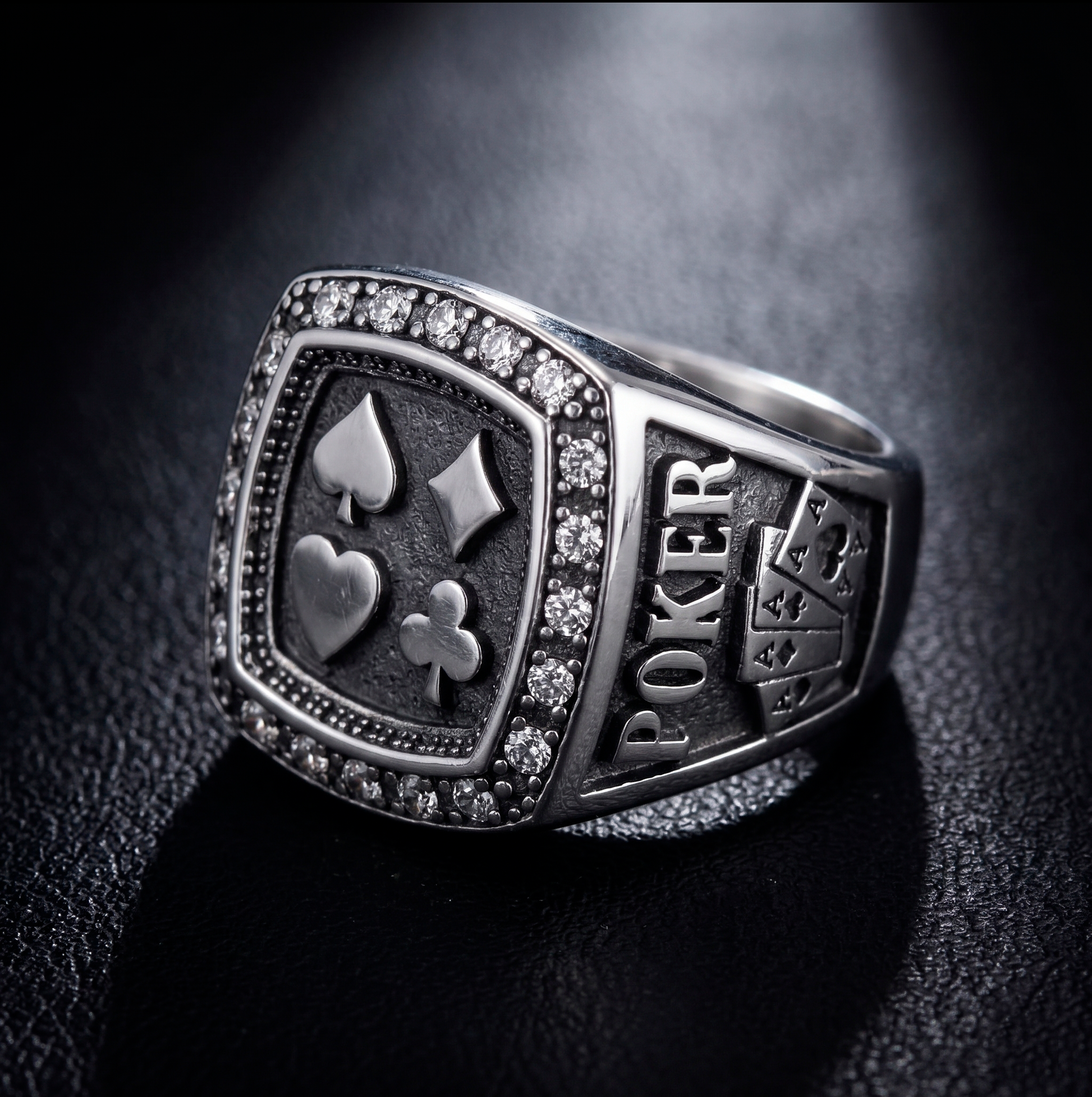 Men's sterling silver poker signet ring showcasing four card suits and embedded stones on a premium black background by Indigo Jewelry.