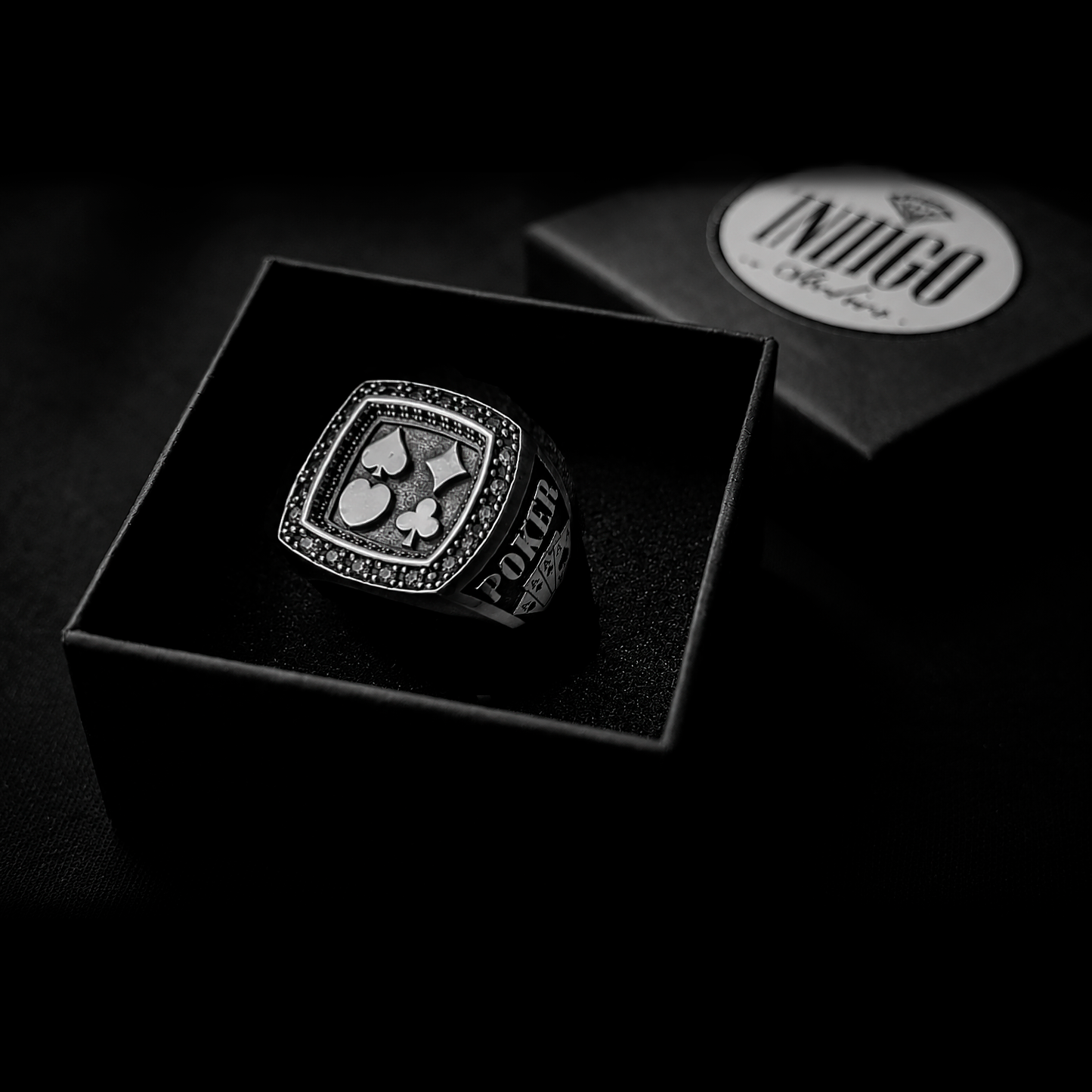 The exclusive silver poker ring unboxed inside the signature black Indigo Jewelry gift packaging.