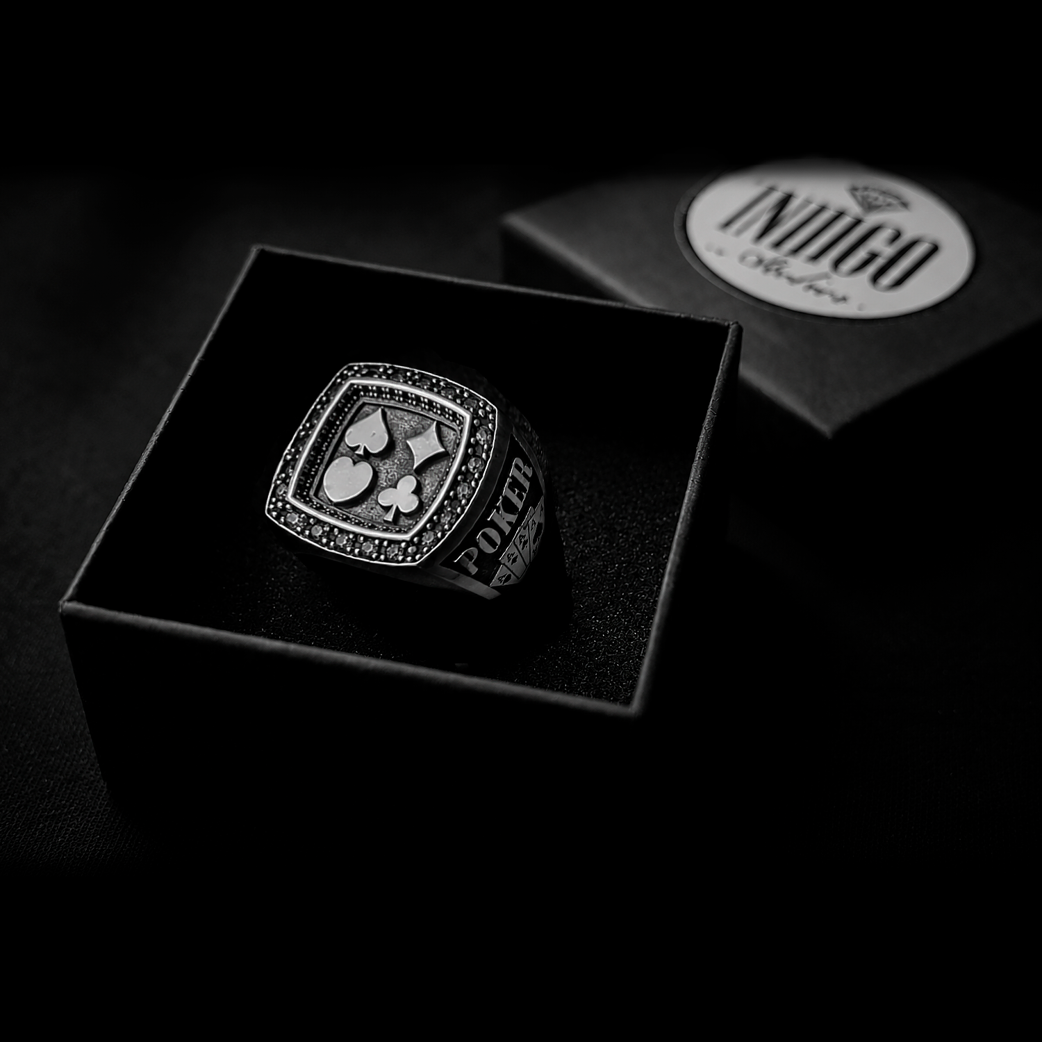 The exclusive silver poker ring unboxed inside the signature black Indigo Jewelry gift packaging.