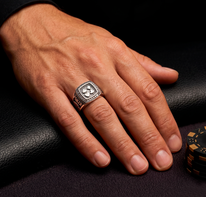 Close-up of the premium silver poker signet ring by Indigo Jewelry on a man's hand at a casino table.